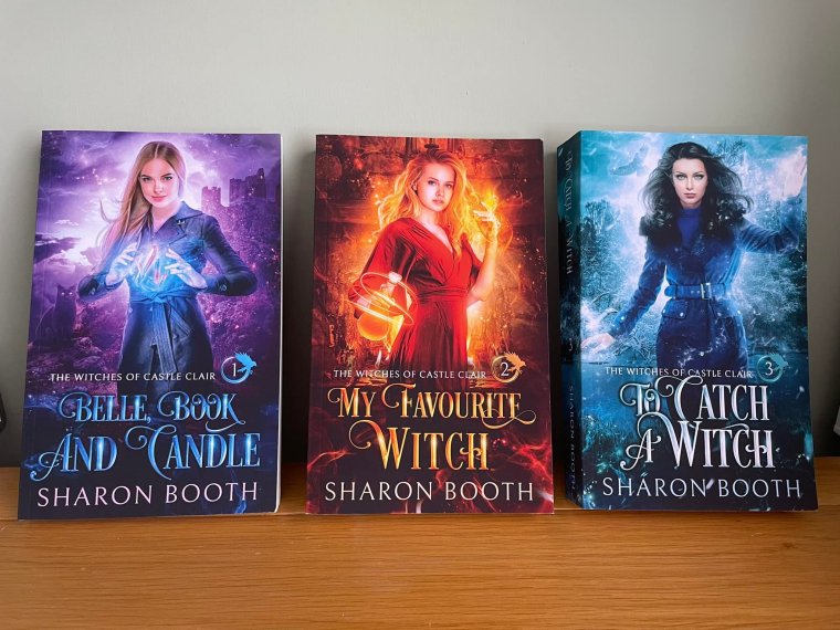 Photo of The Witches of Castle Clair series by Sharon Booth.
3 books each has a modern witch on it,
Belle, Book and Candle is predominently purple
My Favourite Witch is orange
To Catch a Witch is blue